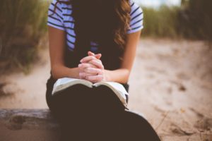 Woman praying with her bible.